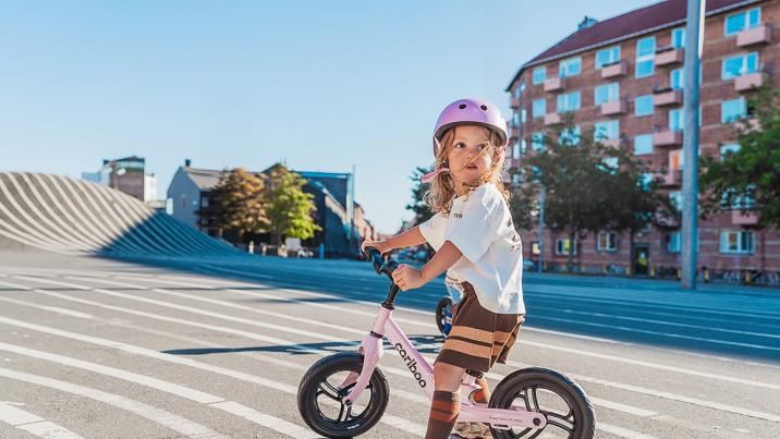 Dziecko uczące się jazdy na rowerku biegowym dopasowanym do wzrostu i długości nóg