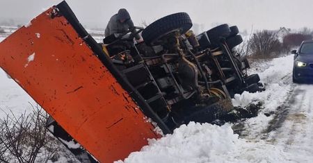 Pług śnieżny złapał pobocze, przewrócił się na bok w rowie. Kierowca i pasażer opuścili pojazd o własnych siłach