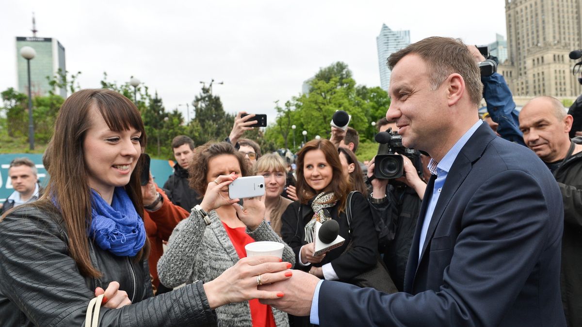 Andrzej Duda rozdaje kawę przed wejściem do metra.