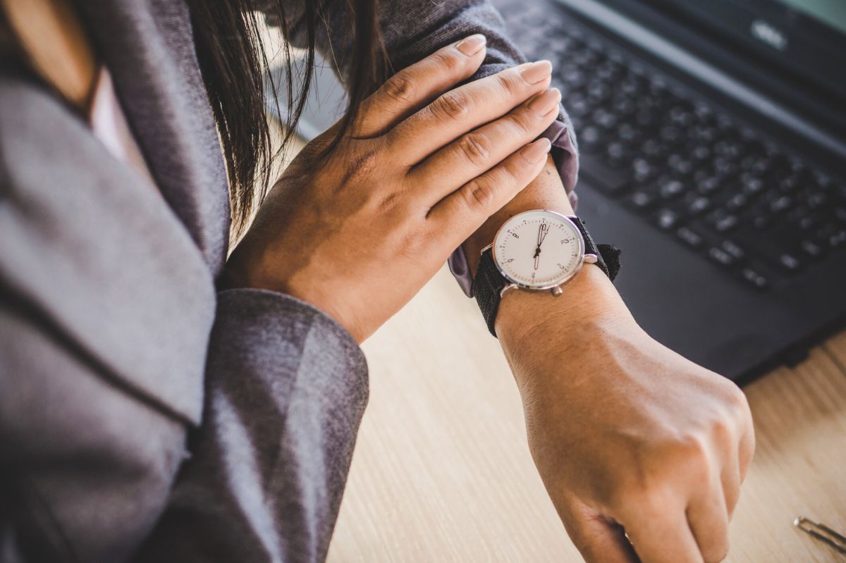 The woman looks at her watch.