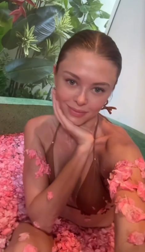 Joanna Opozda w wannie wypełnionej kwiatami