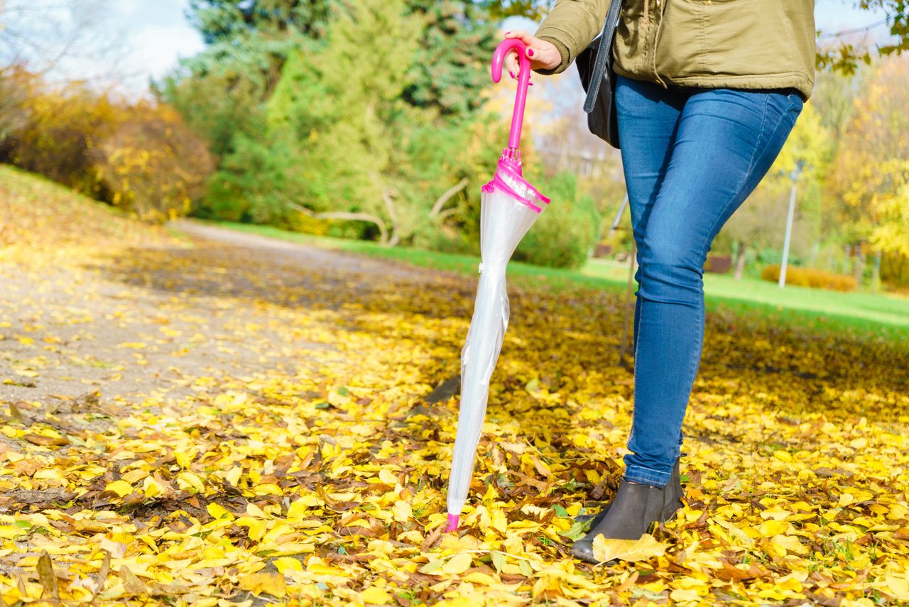 Woman walking in park with umbrella
