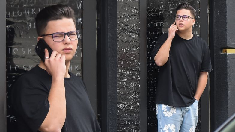 Allan Krupa pali papierosa przed butikiem