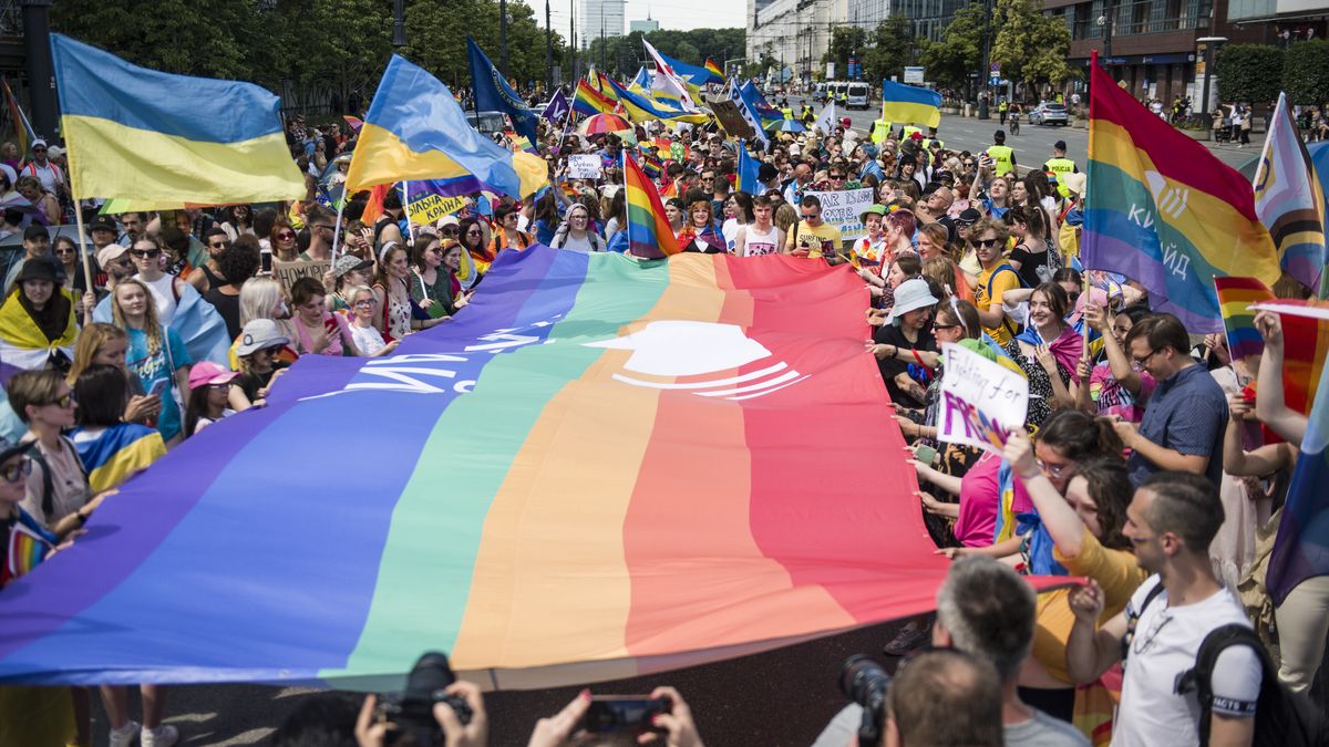 WARSAW, MAZOWIECKIE, POLAND - 2022/06/25: People hold rainbow and Ukrainian flags during the Warsaw Pride. The Kyiv Pride organisation joined the march of the Equality Parade in Warsaw to mark their 10th anniversary and Ukrainian LGBTQ+ people's rights. Warsaw and Kyiv Pride are marching together in Polish capital this year, because of the Russian invasion in Ukraine. The Warsaw Pride, also known as the Equality Parade, brought thousands of people to the streets of Warsaw, to spread the ideas of freedom, equality and tolerance. (Photo by Attila Husejnow/SOPA Images/LightRocket via Getty Images)
