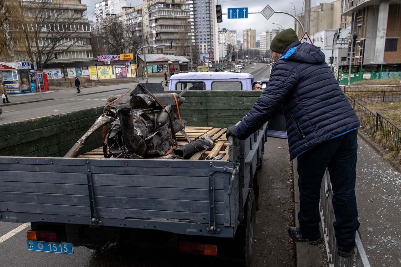 Mężczyzna przygląda się szczątkom rakiety na ulicach Kijowa.