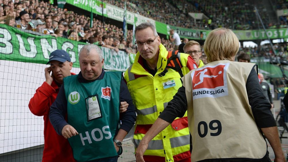 Kamerzysta opuszcza stadion w Wolfsburgu w asyście służb medycznych