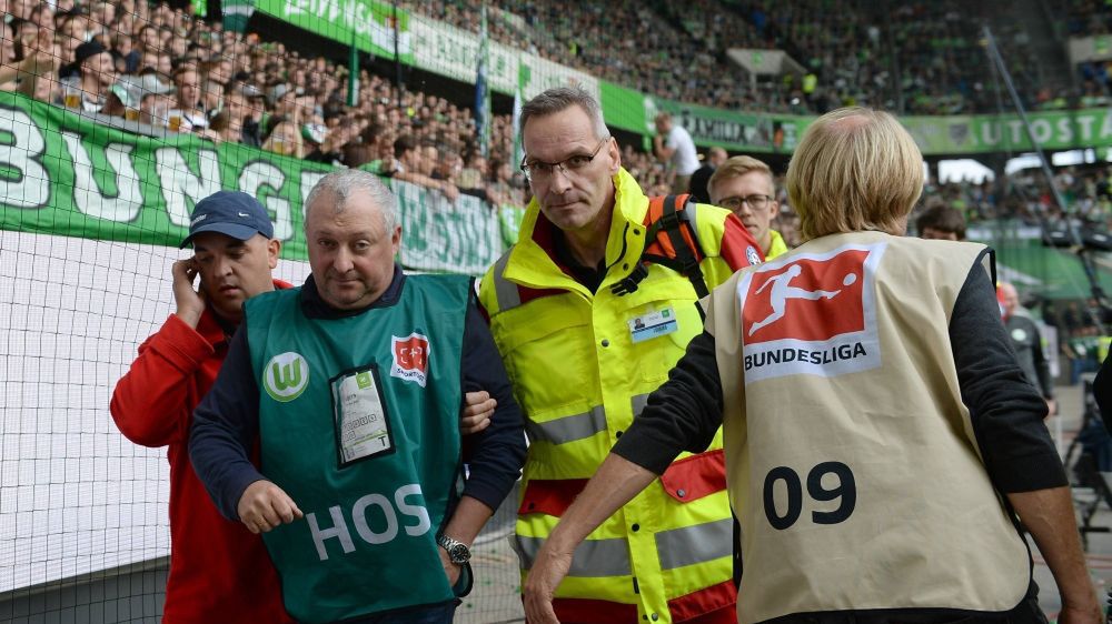 East News / Matthias Koch/Imago Sport and News/East News / Kamerzysta opuszcza stadion w Wolfsburgu w asyście służb medycznych