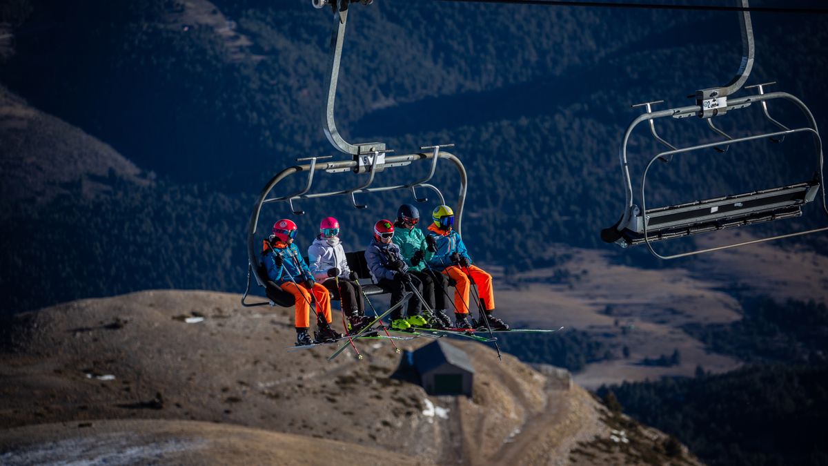 Skiers ride a chair lift, backdropped by a snow-less valley, at the Masella ski resort in Girona, Spain, on Thursday, Jan. 5, 2023. Warming temperatures mean the vast majority of the worlds ski resorts already rely on artificial snow to boost snowpack and prolong the season, but a record run of mild weather in late December means even snowmaking is no longer possible in some areas. Photographer: Angel Garcia/Bloomberg via Getty Images
