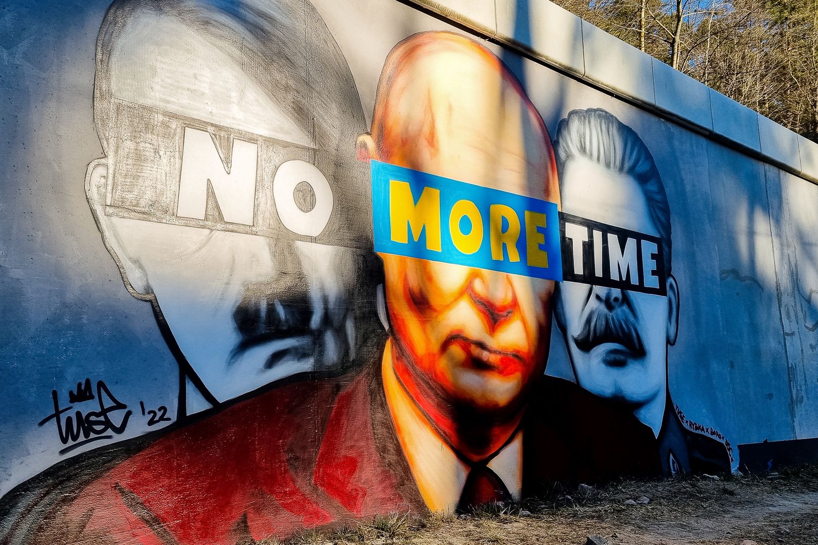 Na zdjęciu gański mural przedstawiający wizerunki Adolfa Hitlera, Władimira Putina i Józefa Stalina. Ich oczy przysłania napis "no more time"