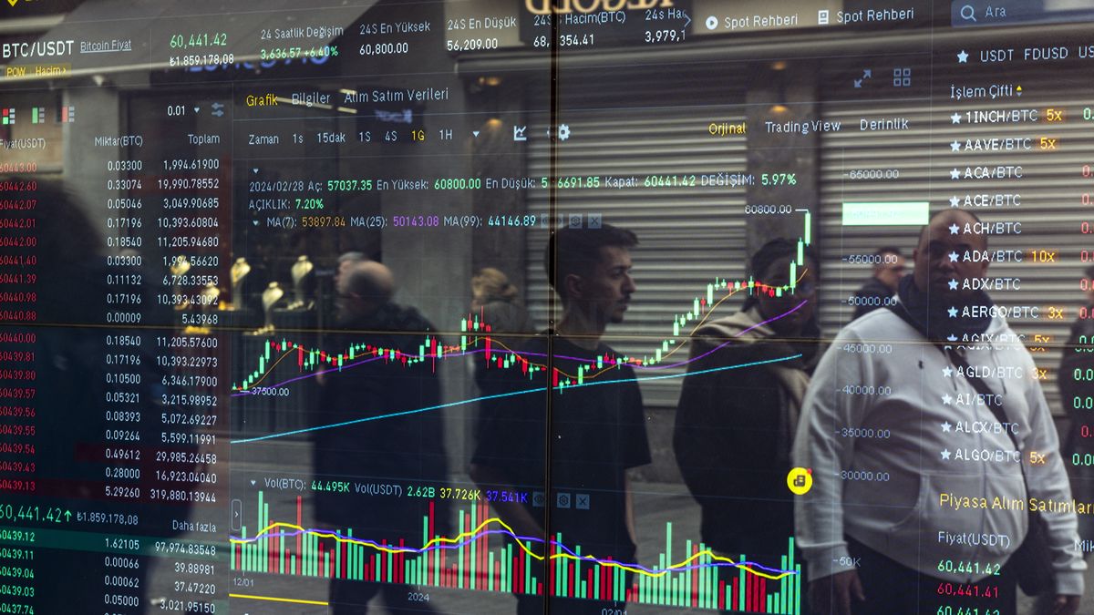 People are passing by a Bitcoin office in Istanbul, Turkey, on February 28, 2024. Bitcoin has increased by nearly fifty percent in the last 30 days, reaching the 64 thousand level. (Photo by Umit Turhan Coskun/NurPhoto via Getty Images)