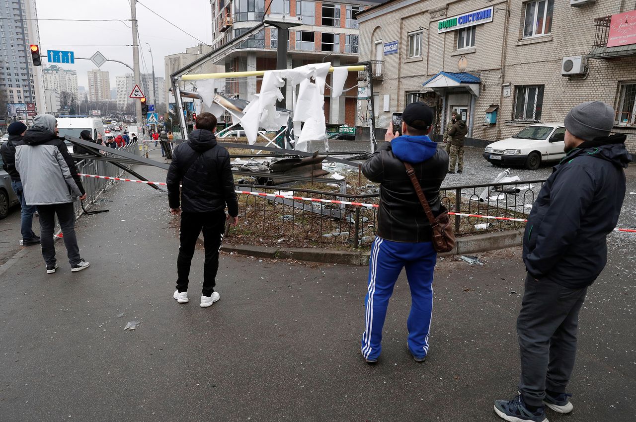 Ludzie patrzą na pocisk, który spadł na ulice w Kijowie.
