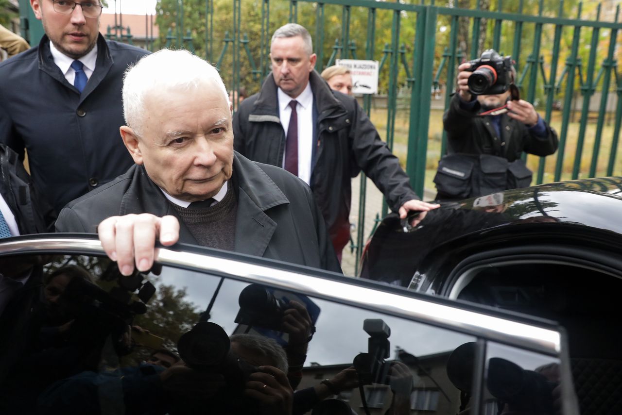 Jarosław Kaczyński odprowadzany przez ochroniarza po oddaniu głosu w wyborach parlamentarnych