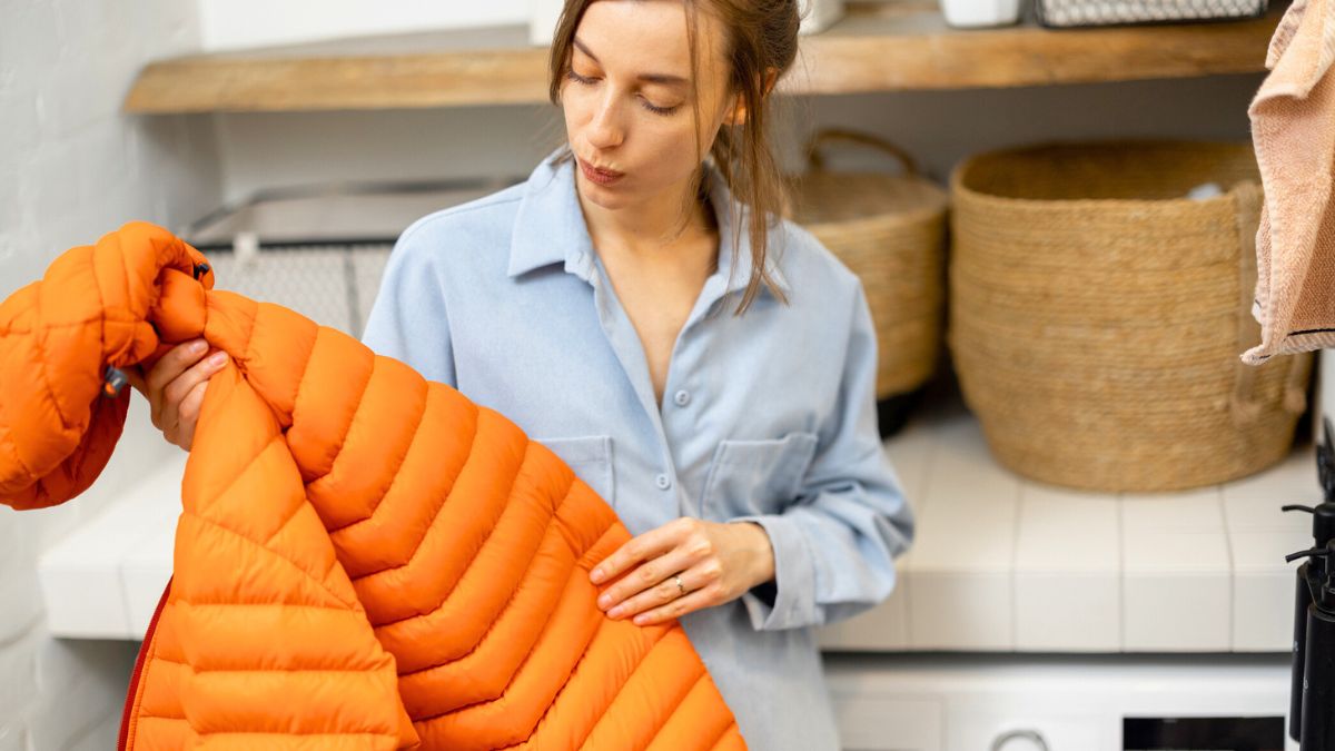 Kobieta trzyma kurtkę w rękach