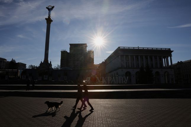 Ludzie na spacerze z psem w Kijowie.