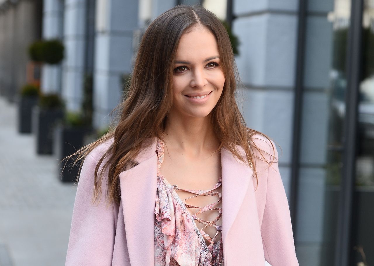 Anna Wendzikowska pozuje w sukience na lato. Uwagę zwracają buty i oryginalny kapelusz