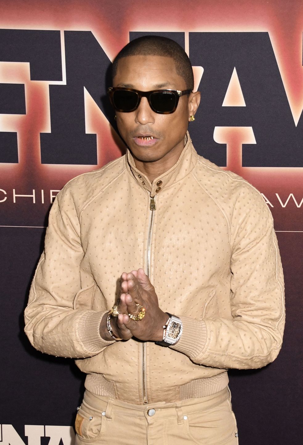 Pharrell Williams oślepia złotym uśmiechem na ściance