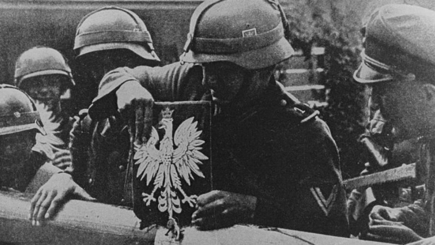 Niemieccy żołnierze zrywają polskie godło ze szlabanu granicznego, 1 września 1939 r.