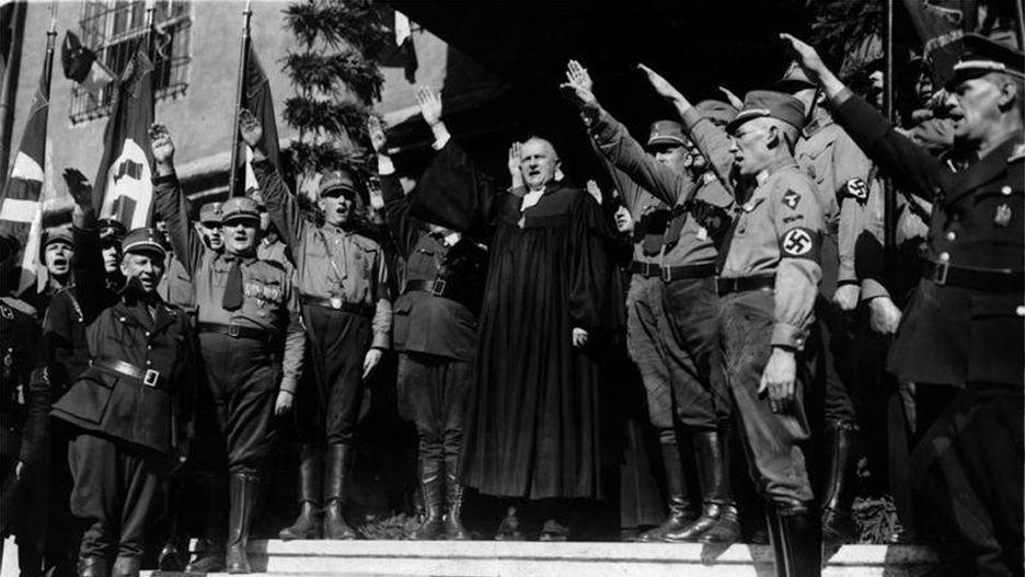 Biskup Ludwig Müller wznosi nazistowskie pozdrowienie w czasie synodu niemieckich ewangelików, 27 sierpnia 1933 r.