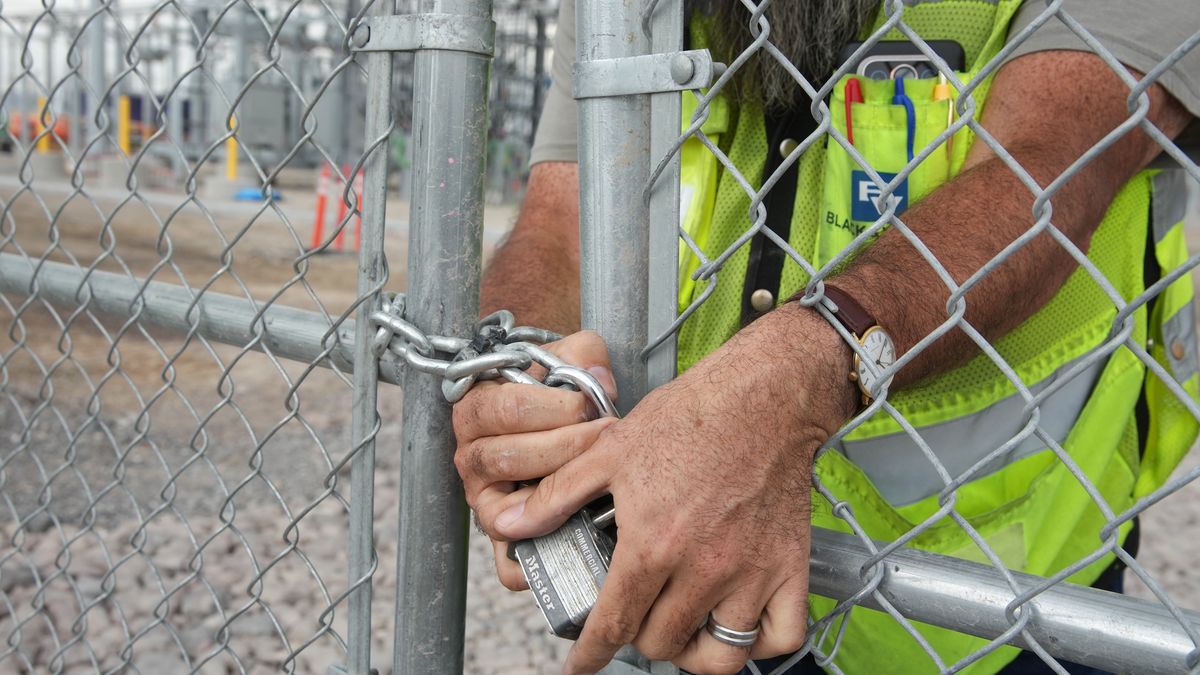A worker padlocks the gate at an electrical substation under construction at the site of a new QTS Eagle Mountain data center in Eagle Mountain, Utah, US, on Friday, Aug. 28, 2026. QTS Realty Trust Inc. is an owner, developer, and operator of carrier-neutral and multi-tenant data centers. Photographer: George Frey/Bloomberg via Getty Images