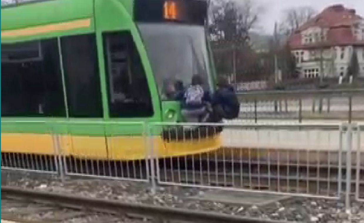 Młodzież jadąc z tyłu tramwaju