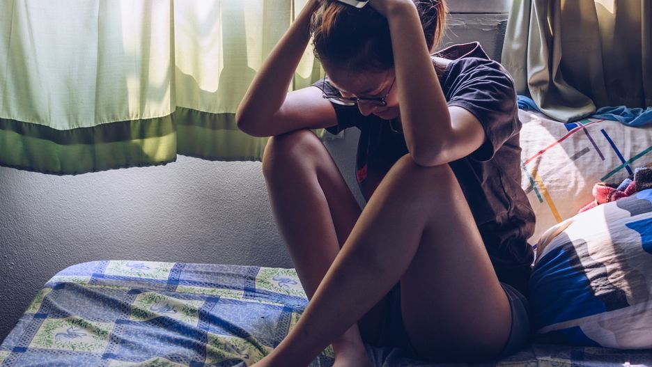 Portrait of depressed/stressed woman sitting alone on the bed in the bedroom.Conceptual of bad condition of broken hearted, sadness, loneliness woman.Boy_Anupong