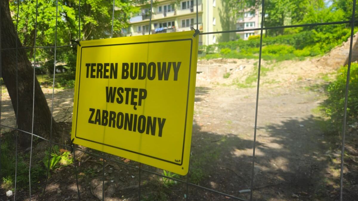 Tabliczka na ogrodzeniu z informacją „Teren budowy, wstęp zabroniony”