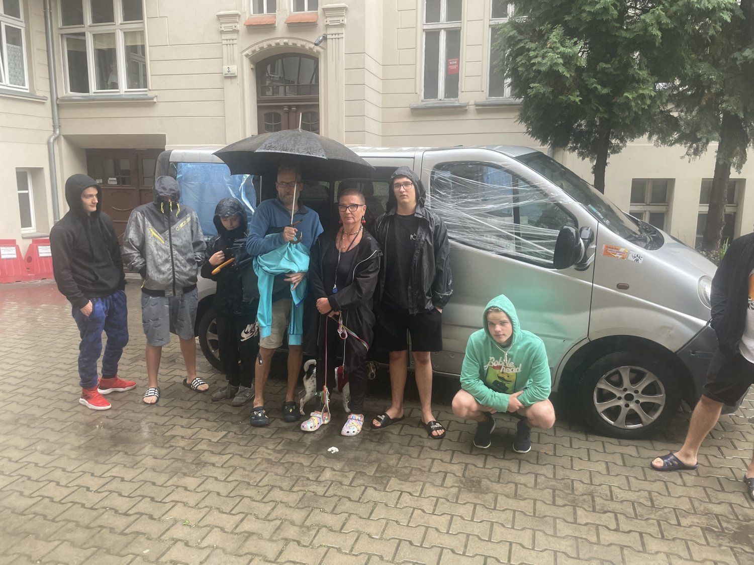 Rodzina obok zdewastowanego auta