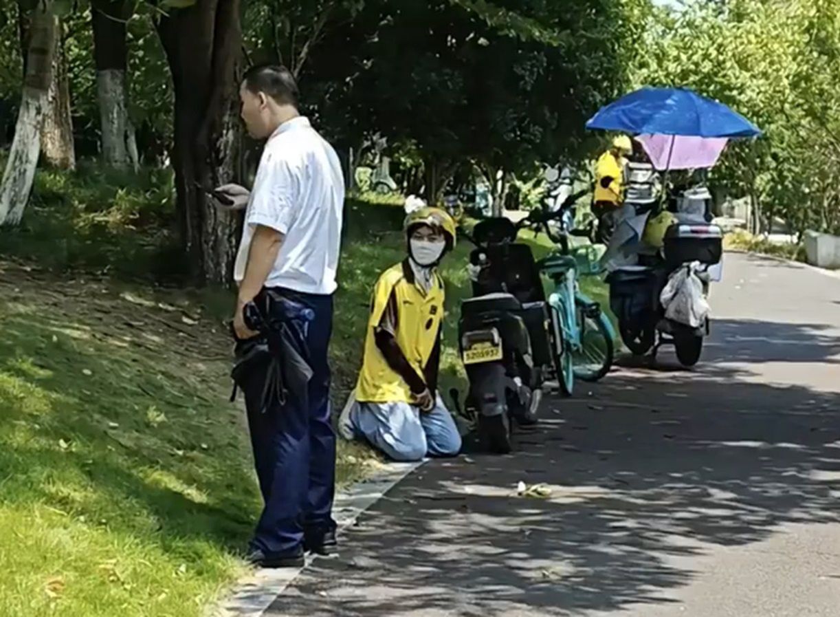 The food delivery person knelt before the security guard to be allowed to pass.