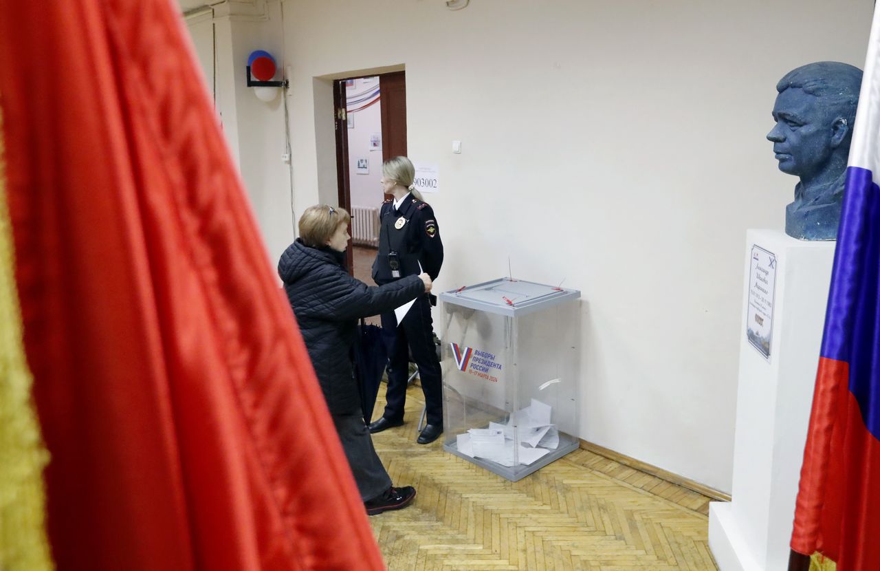 A woman (L) casts her ballot next to the bust of Soviet submariner Alexander Marinesko (R) at a polling station in St. Petersburg, Russia, 17 March 2024. The Federation Council has scheduled presidential elections for 17 March 2024. Voting will last three days: March 15, 16 and 17. Four candidates registered by the Central Election Commission of the Russian Federation are vying for the post of head of state: Leonid Slutsky, Nikolai Kharitonov, Vladislav Davankov and Vladimir Putin. EPA/ANATOLY MALTSEV Dostawca: PAP/EPA.