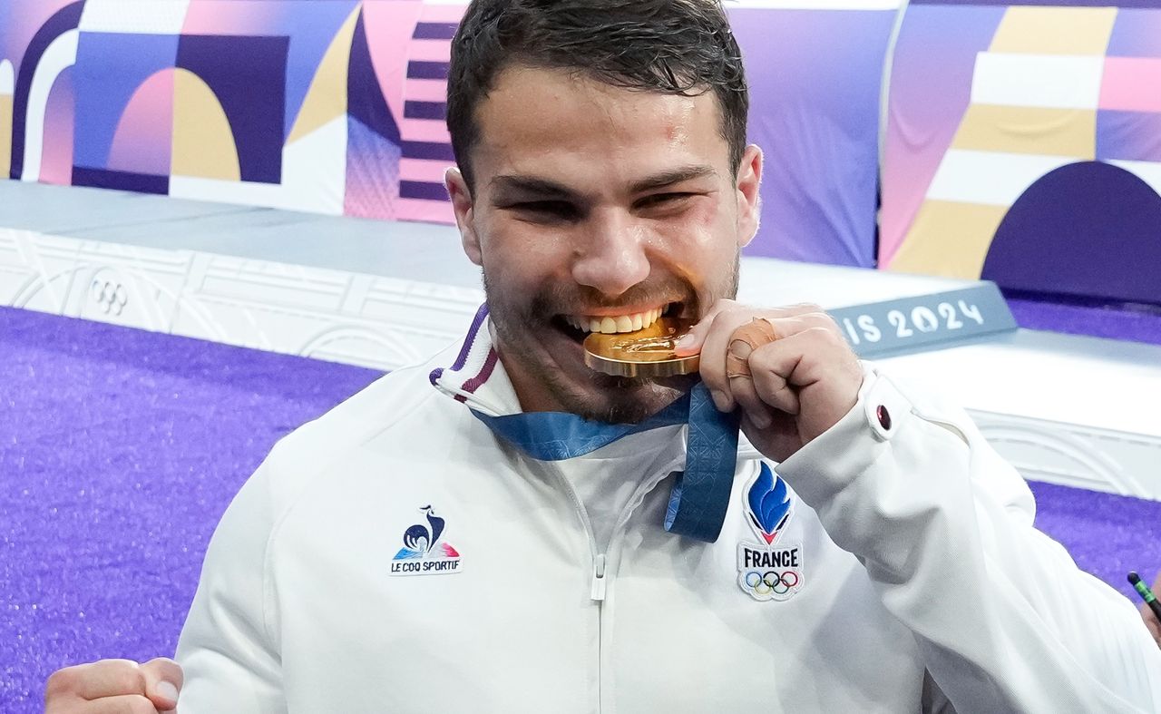 Antoine Dupont bites his gold medal on the first day of the Olympic Games in France.