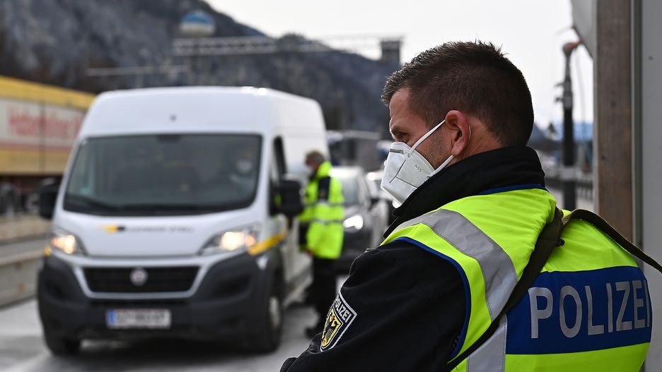 KIEFERSFELDEN, GERMANY - FEBRUARY 15: A German border policeman stands guard at the boarder to Austria as cars queue to enter Germany from the Austrian province of Tyrol after German authorities recently announced strict measures on February 15, 2021 near Kiefersfelden, Germany. Germany has imposed strict entry restrictions for Tyrol and the Czech Republic, effectively sealing the borders and making exceptions for German citizens and residents as well as truck drivers, all of whom must show a recent COVID test and go into quarantine upon arrival. German authorities are seeking to stem the spread of mutations of the novel coronavirus. (Photo by Lennart Preiss/Getty Images)