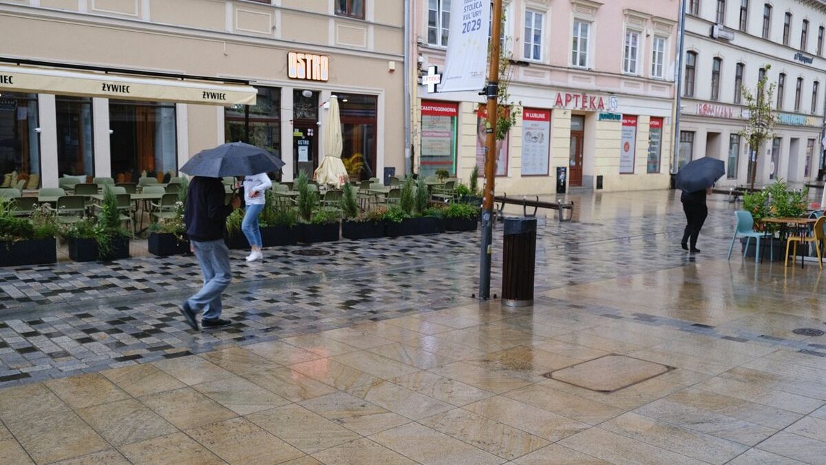 Opady deszczu, przechodnie z parasolkami