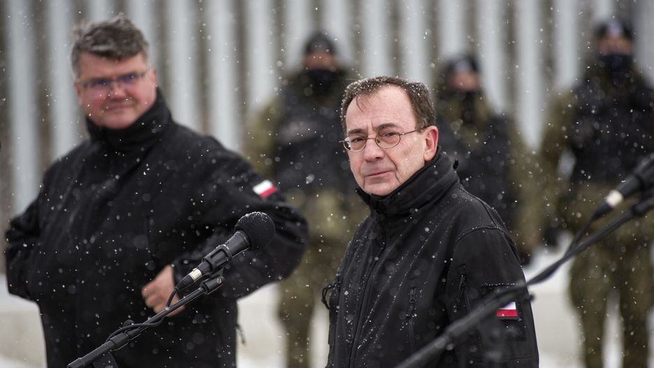 NOMIKI, PODLASKIE, POLAND - 2022/11/18: Minister of Interior and Administration Mariusz Kaminski (R) and Deputy Minister of Interior and Administration Maciej Wasik (L) are seen during a press conference at the border wall near Nomiki village. Polands Interior Minister Mariusz Kaminski inspected the initial installation phase of high-tech monitoring equipment along a metal wall on the border with Belarus geared toward preventing thousands of migrants from crossing into the European Union.
The head of the Ministry of Interior and Administration announced the completion of works on the first section of the electronic barrier on the border with Belarus. Kaminski also said that the 5.5-meter (17-feet) high wall has slashed crossing attempts tenfold. (Photo by Attila Husejnow/SOPA Images/LightRocket via Getty Images)