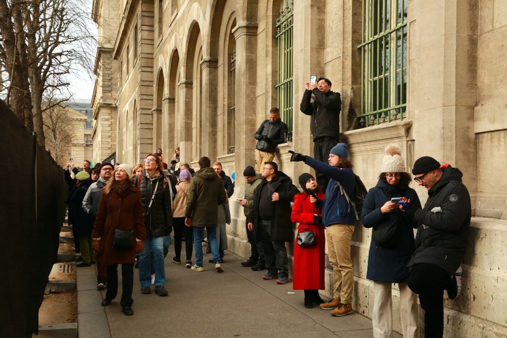 Turyści zza płotu fotografują Notre Dame - zdjęcie z 1 grudnia