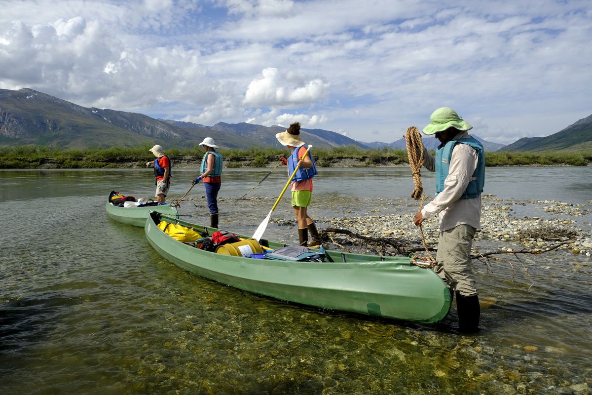 GATES OF THE ARCTIC NATIONAL PARK, AK - JUNE 19: My dad, mom, sister, and brother-in-law prepare the canoes before leaving camp to float down the Noatak River on June 19, 2021 in Gates of the Arctic National Park, Alaska. Before and after our peaceful hours floating the river, each river day required several hours of camp breakdown and setup, loading and unloading canoes at our new campsite, and cooking and cleaning at dinnertime. (Photo by Marlena Sloss for The Washington Post via Getty Images)