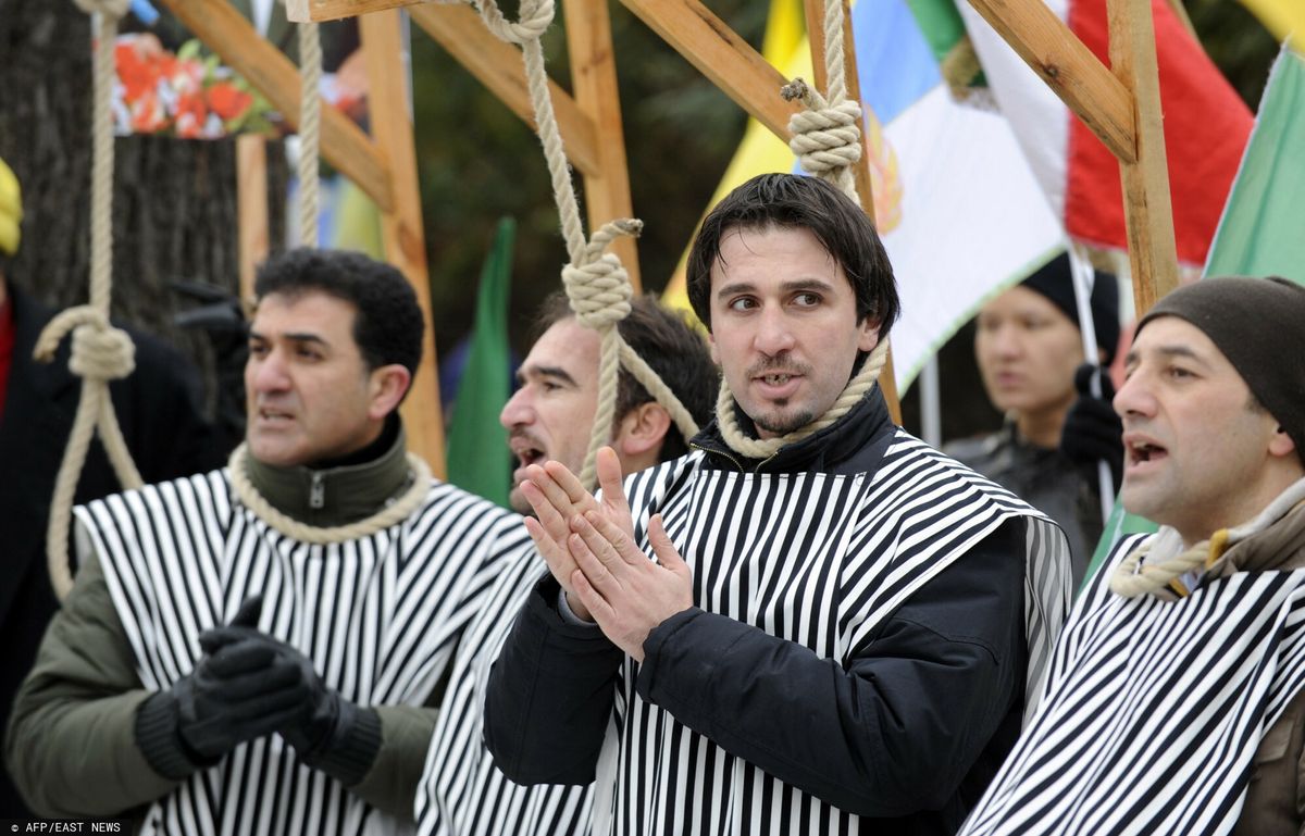 Demonstranci skandujący hasła organizują pozorowaną egzekucję podczas protestu przed ambasadą Iranu w Berlinie, 11 lutego 2010 r. w Berlinie