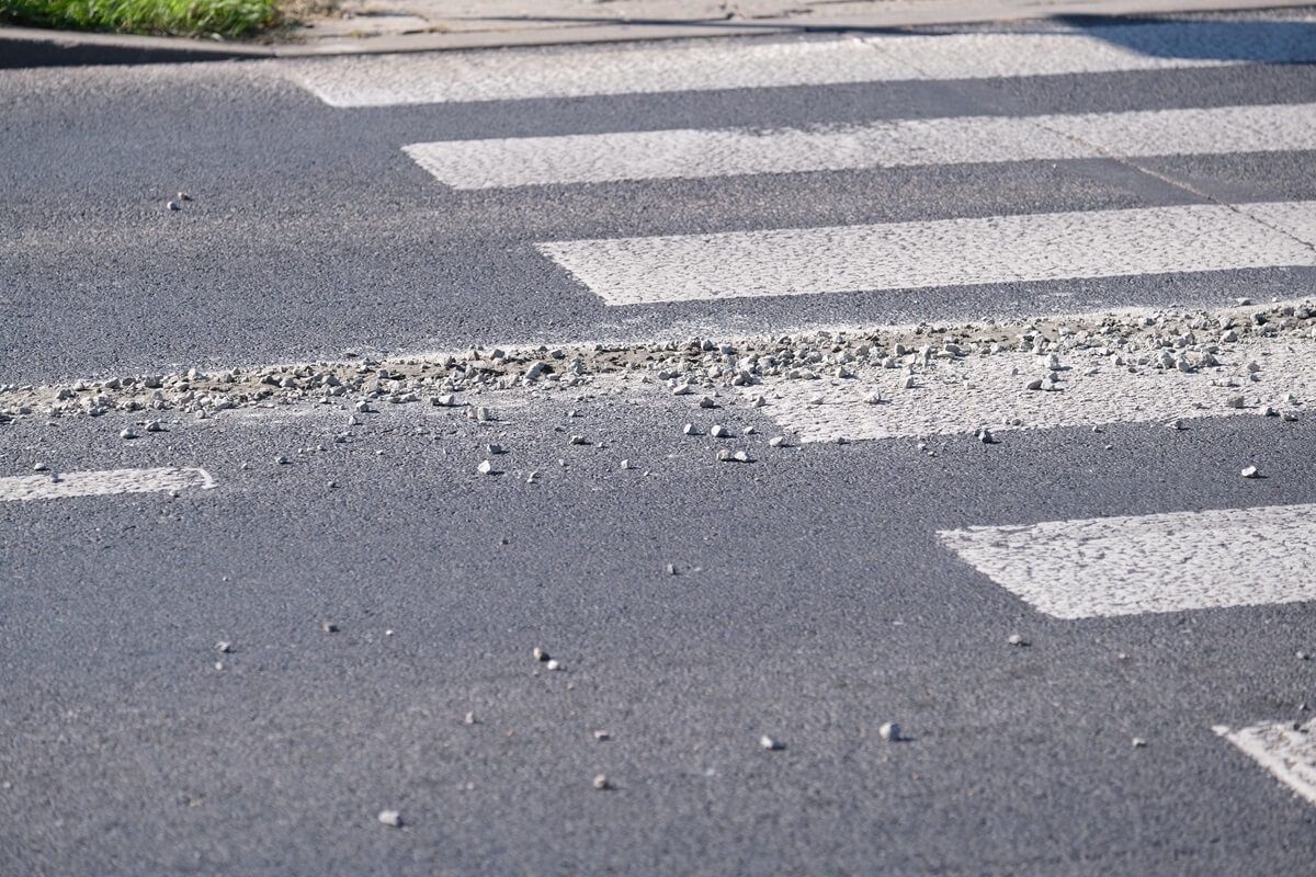 Rozlany beton z kamieniami na jezdni na ul. Podzamcze