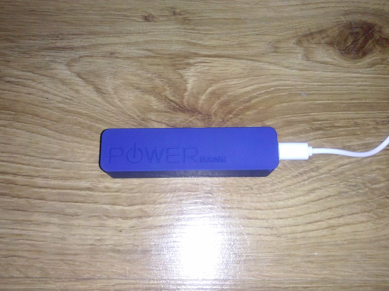 PowerBank podczas ładowania - widok na tłoczone logo na froncie.