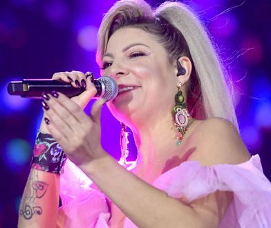 Magdalena Narożna wygina się przy poręczy. Ma na sobie tylko kusą piżamkę