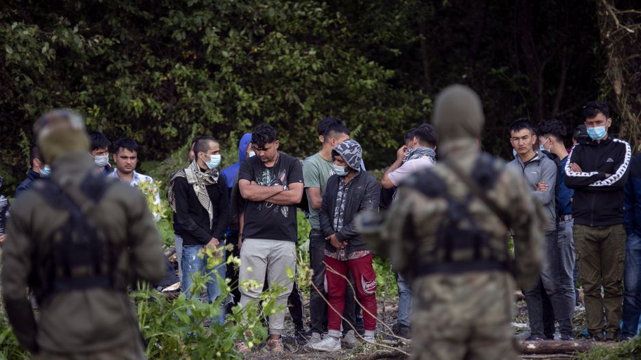 Usnarz Gorny, woj. podlaskie, 12.08.2021. W zwiazku z rosnaca z dnia na dzien iloscia nielegalnych imigrantow przekraczajacych bialorusko-polska granice, Straz Granicza wzmocnila swoje dzialania na granicy z Republika Bialorus na terenie wojewodztwa podlaskiego. Tylko w  ciagu ostatniego weekendu (6-8.08.2021) zatrzymano 349 osob - glownie Irakijczykow i Afganczykow - usilujacych nielegalnie dostac sie do Polski z Bialorusi. Wg. roznych zrodel, imigranci samolotami dostaja sie do Minska, a stamtad sa przewozeni przez bialoruskie sluzby nad granice z Litwa i Polska. Jest to elementem tzw. wojny hybrydowej. N/z wojsko pilnuje zatrzymanych przy granicy z Bialorusia nielegalnych imigrantow, w tym kobiet i dzieci