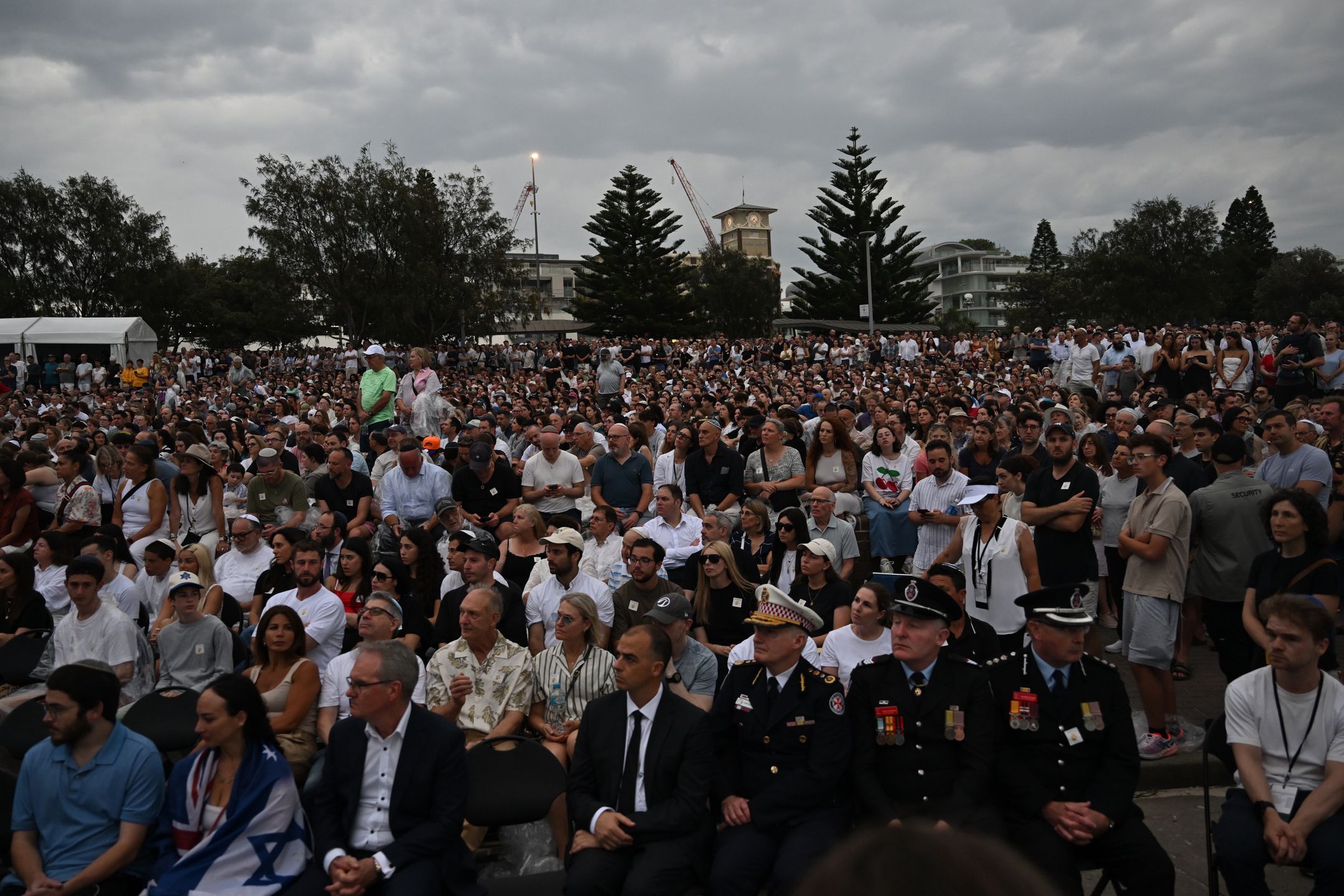 Vigil honors Bondi Beach victims in Sydney
epa12606873 People attend the National Day of Reflection vigil and commemoration for the victims and survivors of the Bondi Massacre at Bondi Beach in Sydney, Australia, 21 December 2025.  EPA/DEAN LEWINS AUSTRALIA AND NEW ZEALAND OUT 
Dostawca: PAP/EPA.
DEAN LEWINS
BONDI PAVILION, FLORAL MEMORIAL, FLOWERS, FLOWER MEMORIAL, NSW, GUNMEN, GUNMAN, SHOOTER, SHOOTERS, ATTACK, SHOOTING INCIDENT, TRAGEDY, VICTIMS, FATALITIES, MASSACRE, JEWISH COMMUNITY, HATE CRIME, ANTISEMITISM, MASS SHOOTING, BONDI BEACH SHOOTING, RELIGIOUS ATTACK, VIOLENCE, MOURNING, COMMUNITY TARGETED, DEATHS, FLORAL TRIBUTE, CASUALTIES, MASS KILLER, TERRORIST, TERRORISM, BONDI VIGIL AND COMMEMORATION, NATIONAL DAY OF REFLECTION
