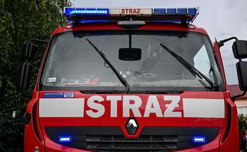 Wóz strażacki na boku. Strażak kompletnie pijany