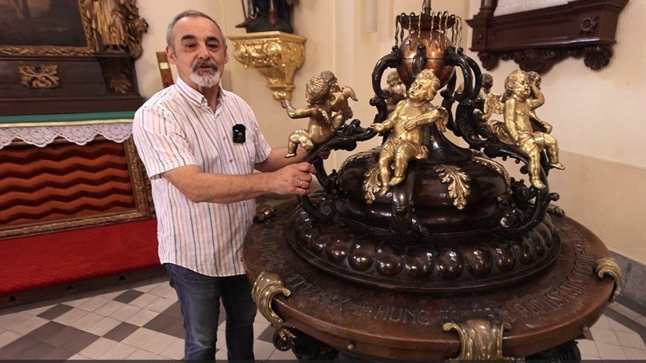 Juliusz Woźny przy tytułowej chrzcielnicy w kościele św. Maurycego