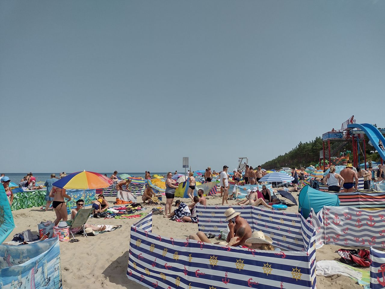 21 lipca 2022 roku. Turyści z parawanami na plaży w Stegnie. 