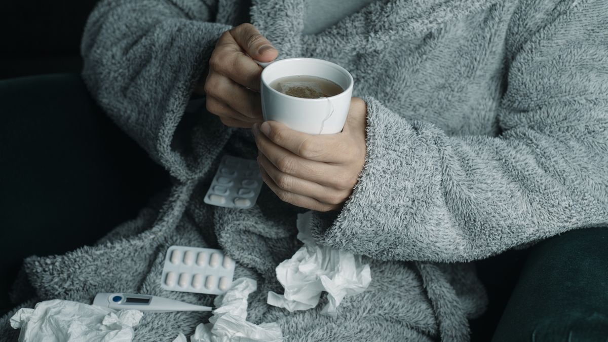 ill man at home warming up with a herbal tea
closeup of an ill man at home, wearing a gray house robe, warming up with a cup of hot herbal tea
nito100