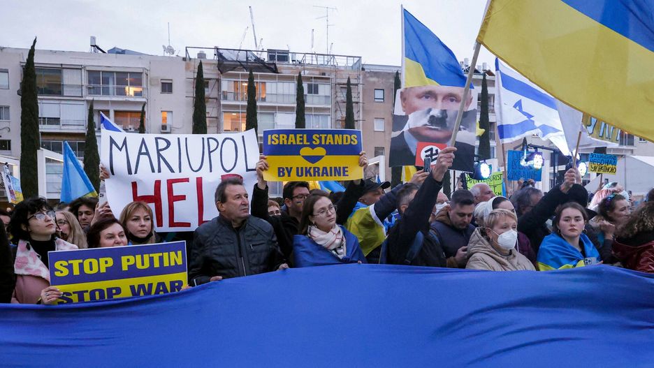 TemporaryDemonstrators wave a giant flag of Ukraine alongside other smaller flags of Ukraine and Israel during a protest against Russia's invasion of Ukraine and ahead of a televised address by the Ukrainian president in Israel's Mediterranean coastal city of Tel Aviv on March 20, 2022. (Photo by JACK GUEZ / AFP)JACK GUEZ