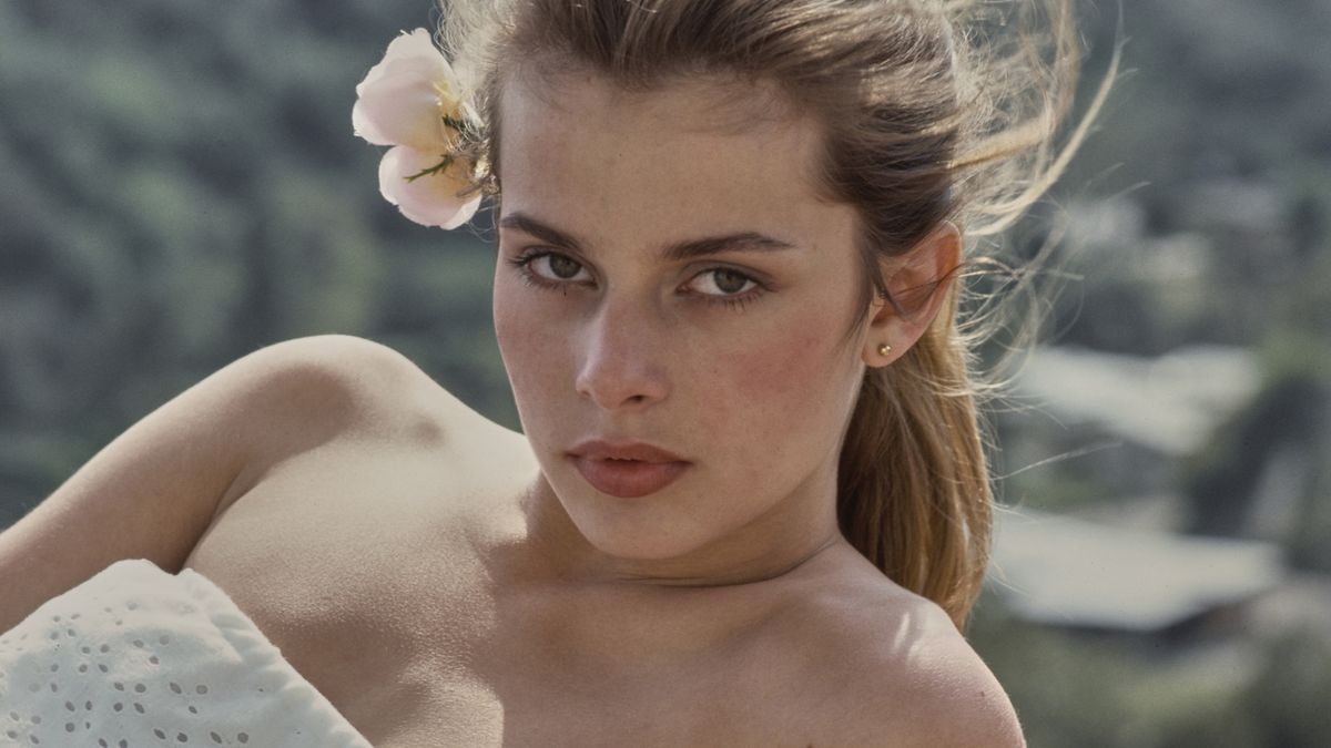German actress and fashion model Nastassja Kinski, wearing a white tube top, a flower in her hair, during a portrait session at her home in the Hollywood Hills neighbourhood of Los Angeles, California, May 1977. (Photo by Michael Ochs Archives/Getty Images)