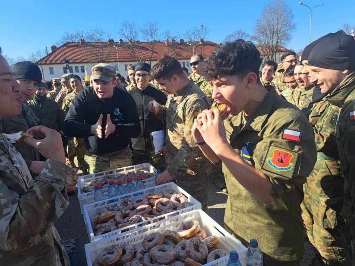 Amerykańscy żołnierze ścigają się z uczniami podczas jedzenia pączków podczas zawodów Iron Panther