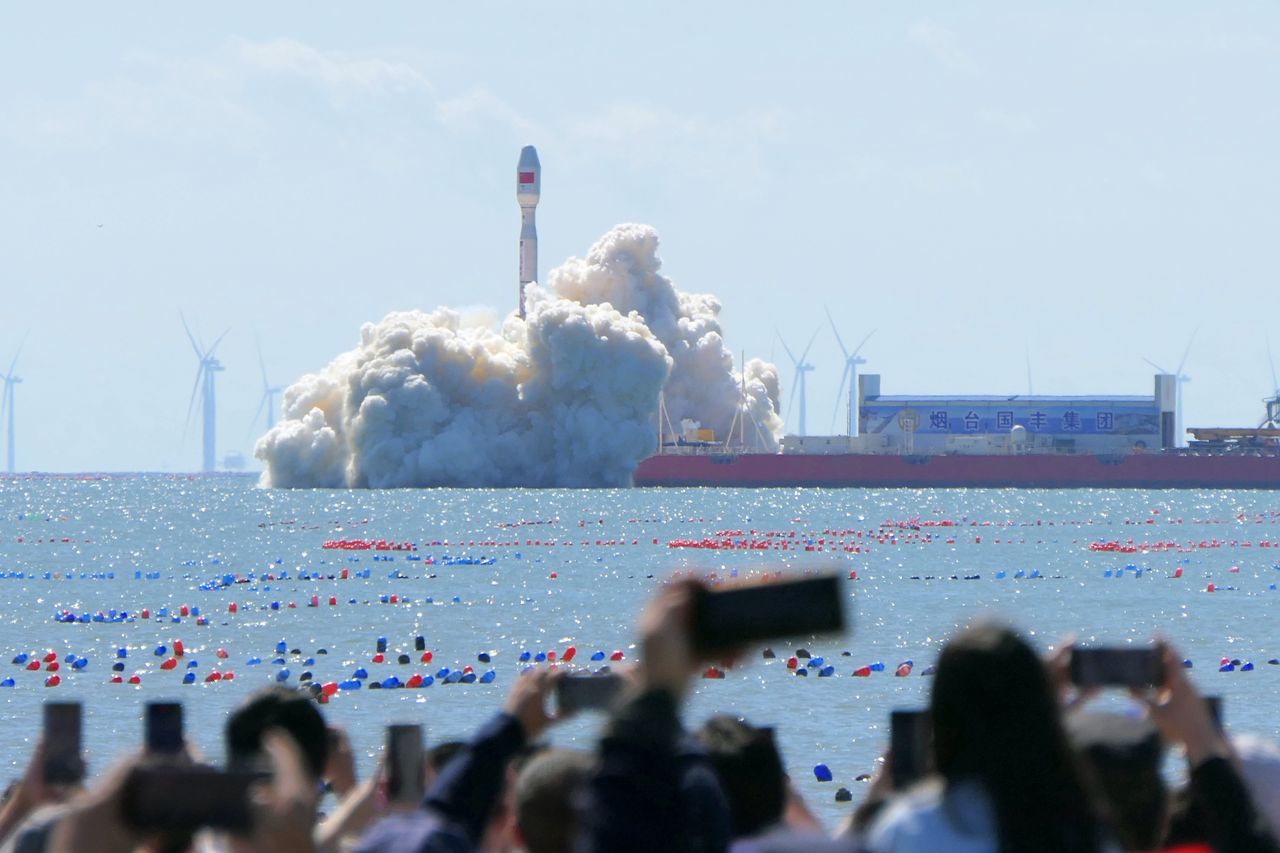 Spectators watch the launch of the Jielong No.3 carrier rocket from the seaside in Haiyang, China, on September 24, 2024. (Photo by Costfoto/NurPhoto via Getty Images)