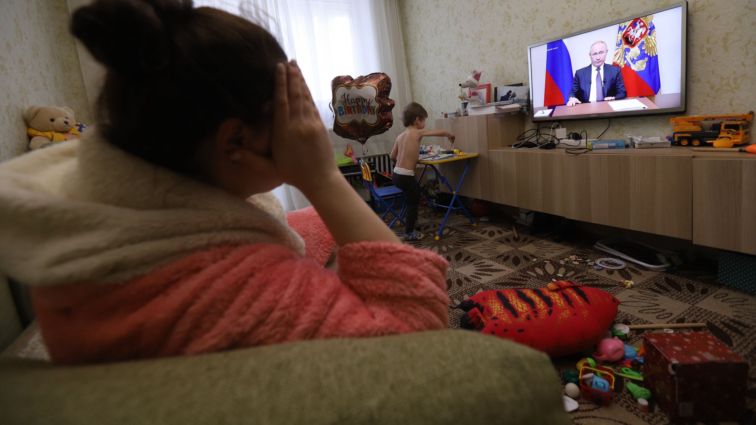 In this photo illustration a woman watching President,SAINT PETERSBURG, RUSSIA - 2020/03/25: In this photo illustration a woman watching President, Vladimir Putin addressing the nation about COVID-19 situation in Russia. Referendum on constitutional amendments postponed indefinitely. At least 658 cases of coronavirus have been confirmed in Russia. (Photo by Sergei Mikhailichenko/SOPA Images/LightRocket via Getty Images)SOPA Imagestv, tv screen, covid19, covid 19, corona virus, pandemic, outbreak, disease